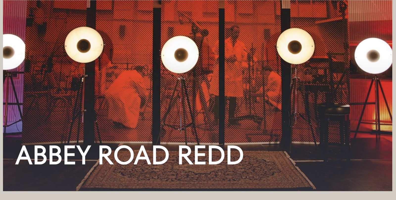 Abbey Road REDD studio lit in red with a row of lamp stands and the words Abbey Road REDD