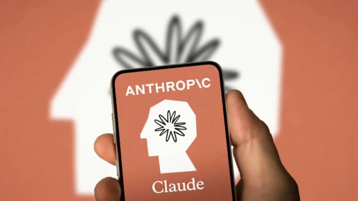 A hand holds a phone showing the Anthropic and Claude logos against a blurred Anthropic backdrop