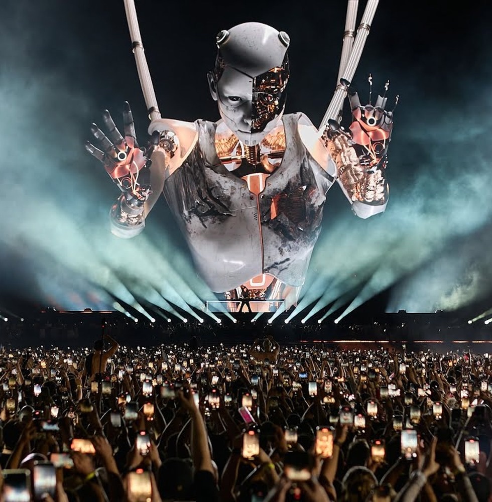 Anyma's giant digital figure above a crowd holding up phones at Sphere in Las Vegas