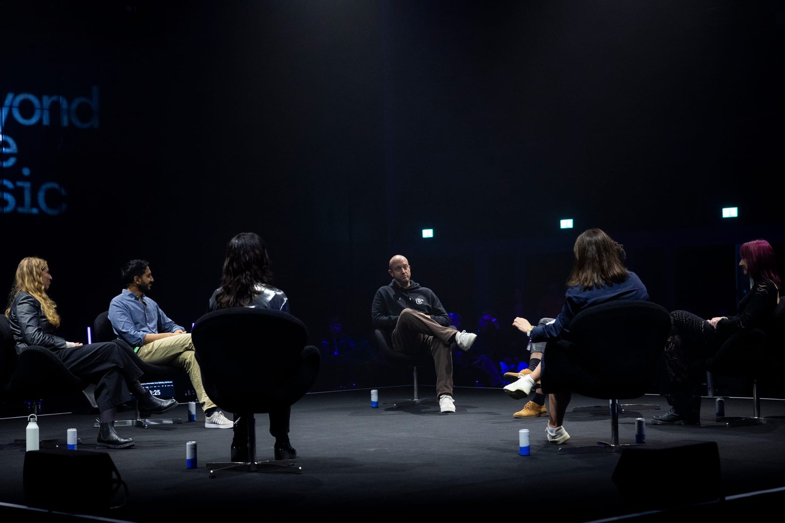Panelists seated on the round stage at the Beyond The Music 2024 AI Summit