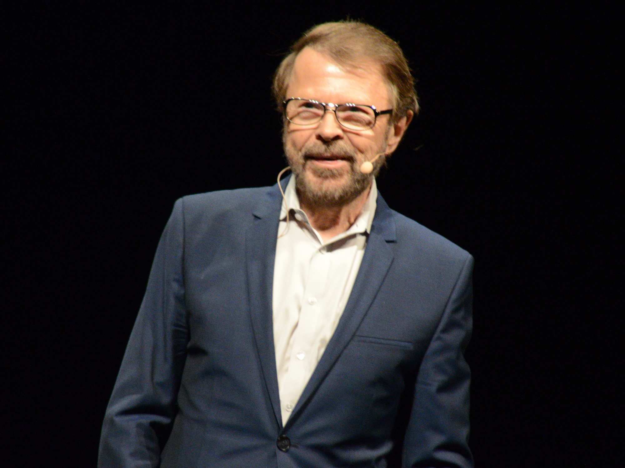 Björn Ulvaeus, ABBA member and CISAC president, speaking on stage with a headset microphone