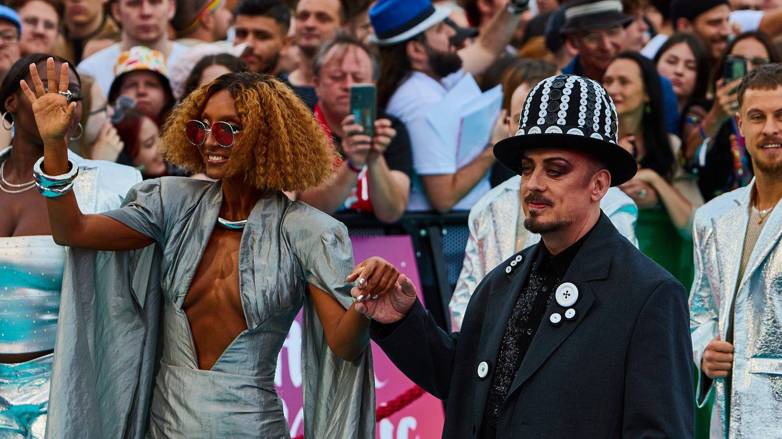 Boy George in a black button-covered hat on the Eurovision Song Contest 2026 turquoise carpet
