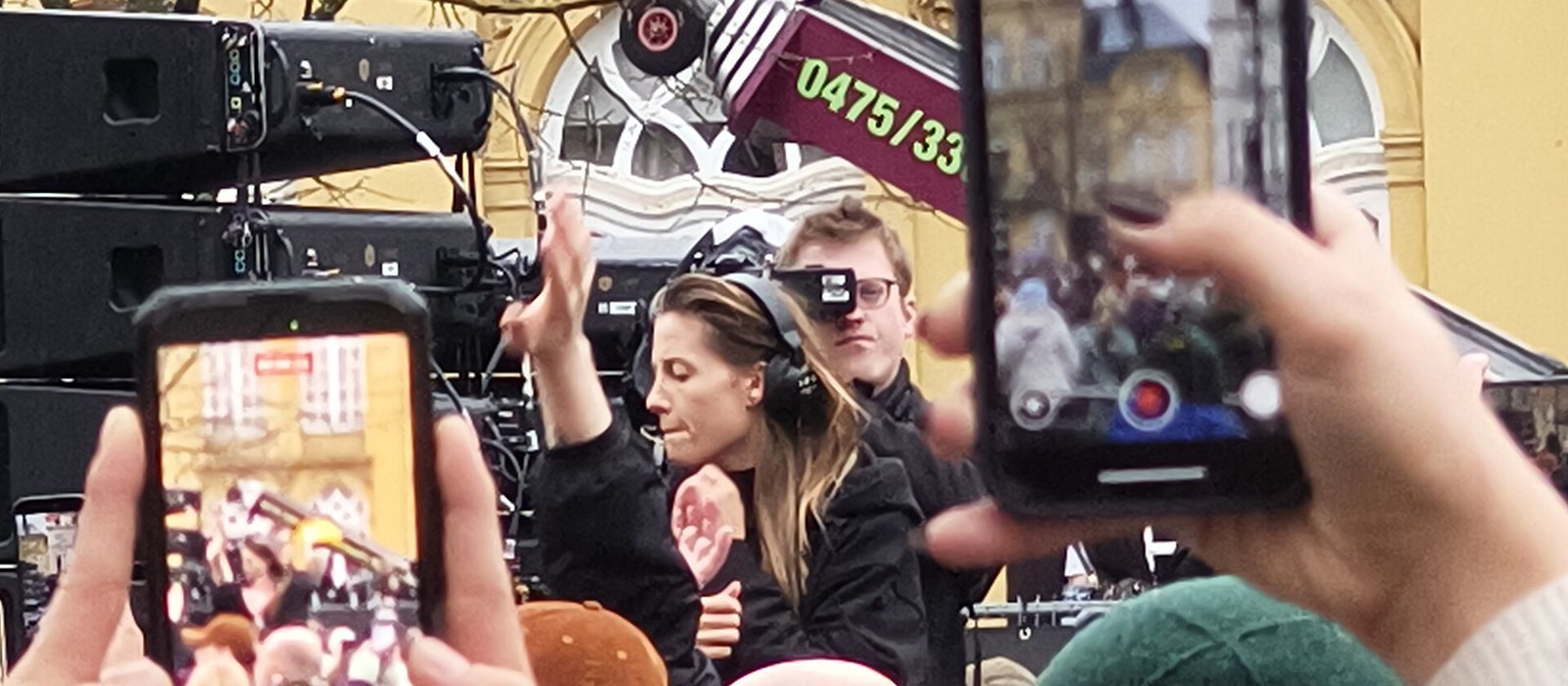 Charlotte de Witte DJing in headphones while fans film her on their phones in 2026
