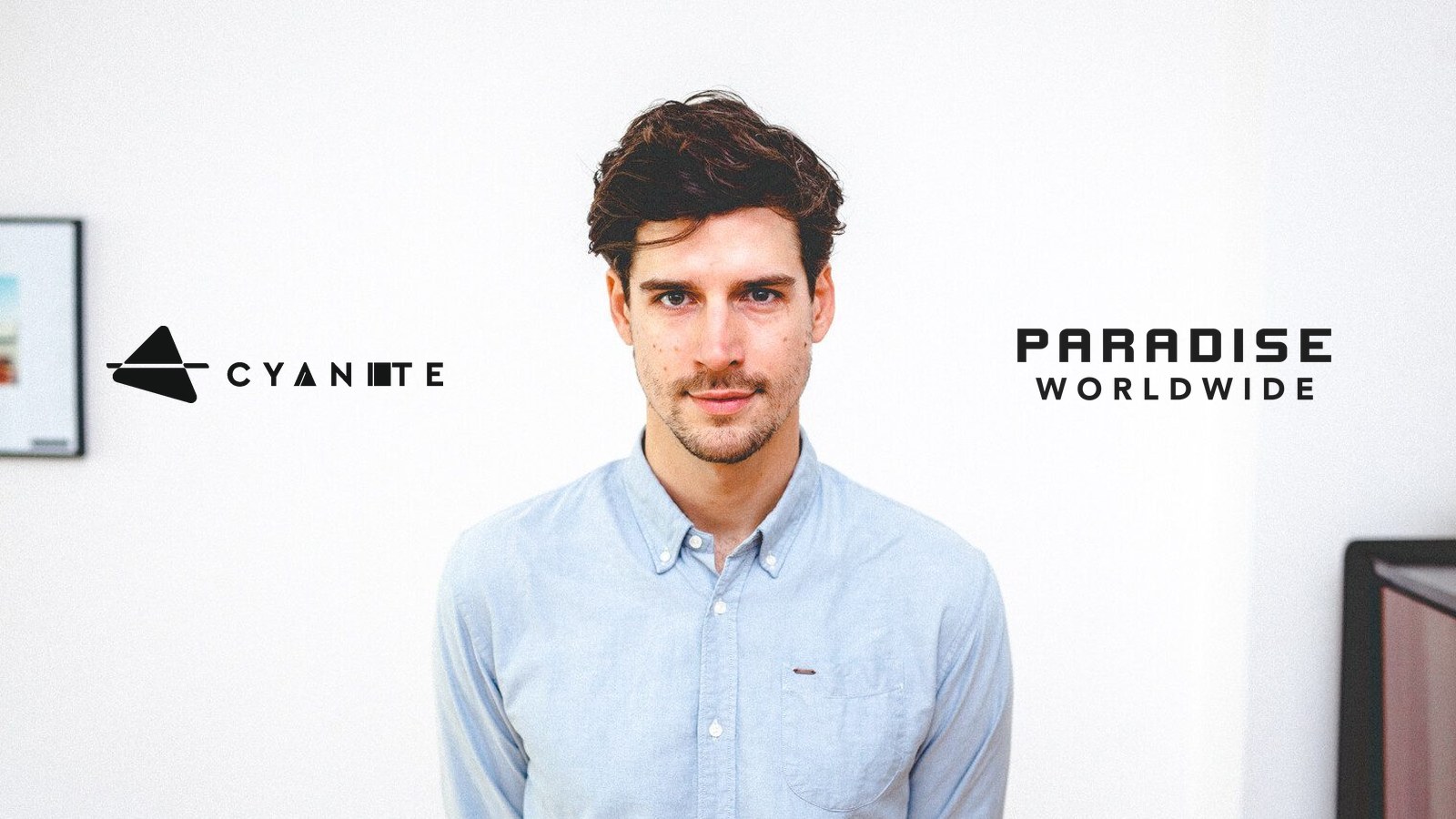 Cyanite CEO Markus Schwarzer standing between the Cyanite and Paradise Worldwide logos