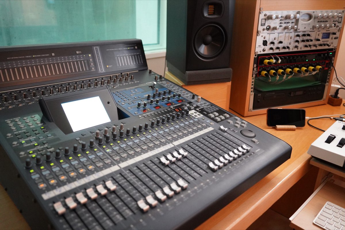 Studio mixing console and monitor speaker in a control room, illustrating spatial audio engineering