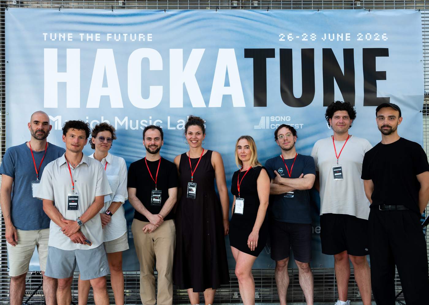 Hackatune 2026 jury members stand together in front of the Hackatune banner in Munich