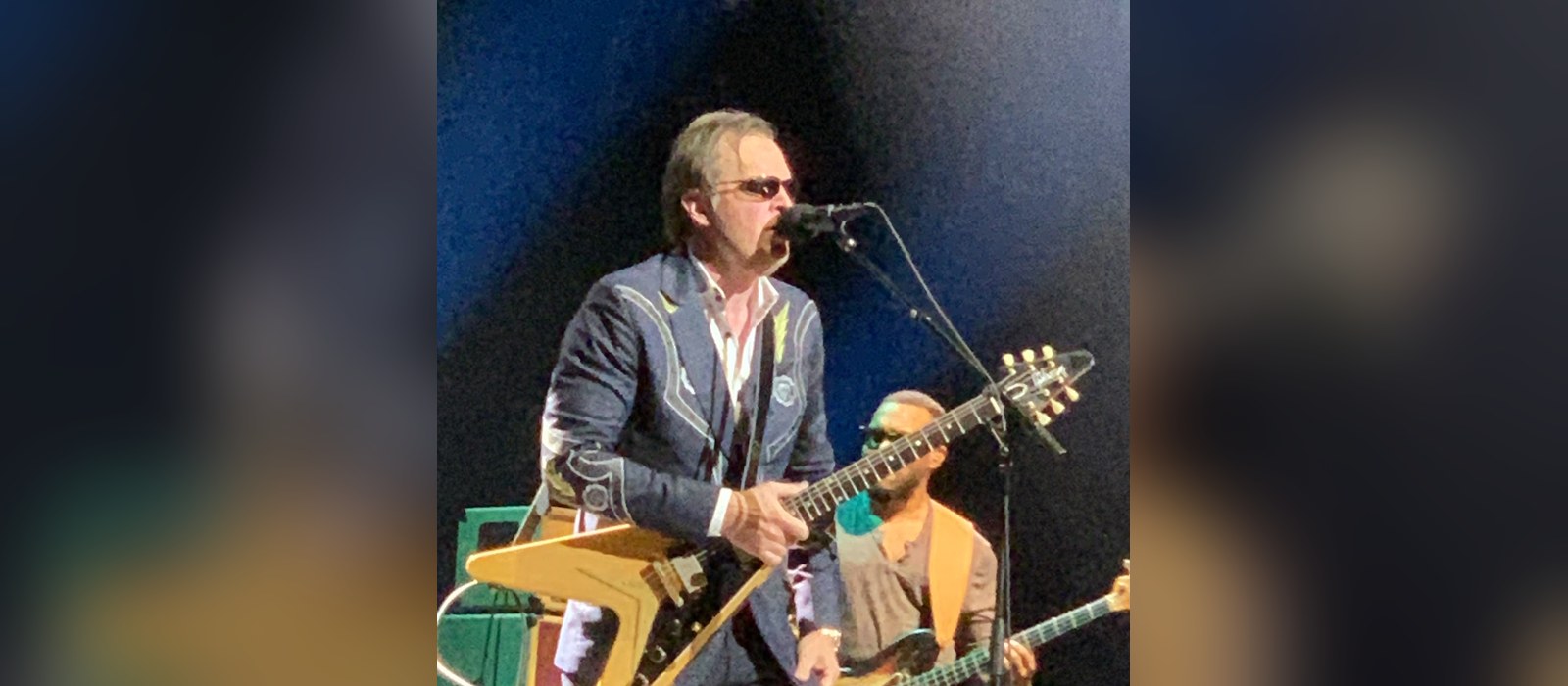 Joe Bonamassa singing and playing a Flying V guitar on stage at the Riverside Theatre in Milwaukee
