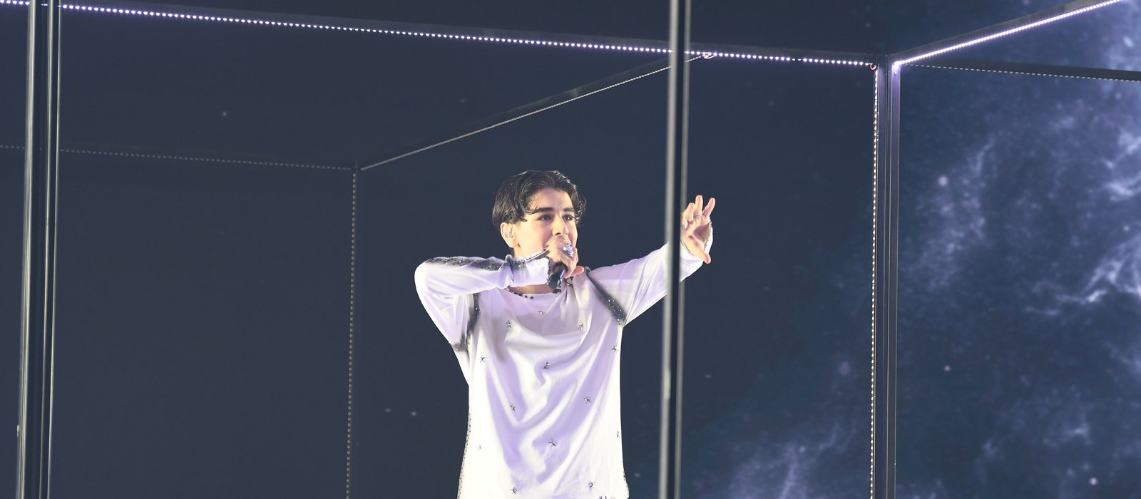 Arwin performing inside a lit glass cube at a Melodifestivalen 2025 rehearsal in Jönköping