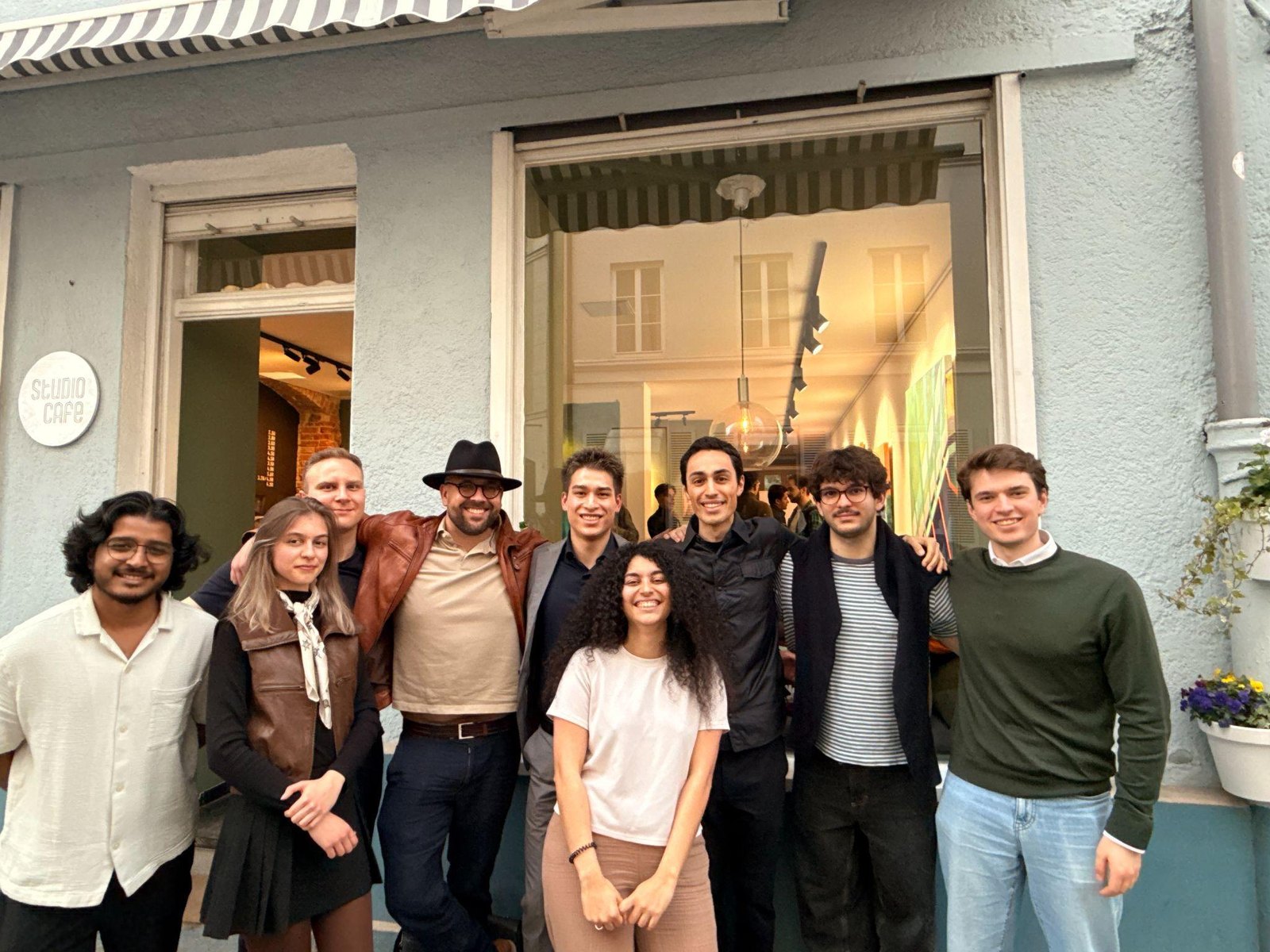 Munich Music Labs team members smile together outside Studio Café with arms around each other