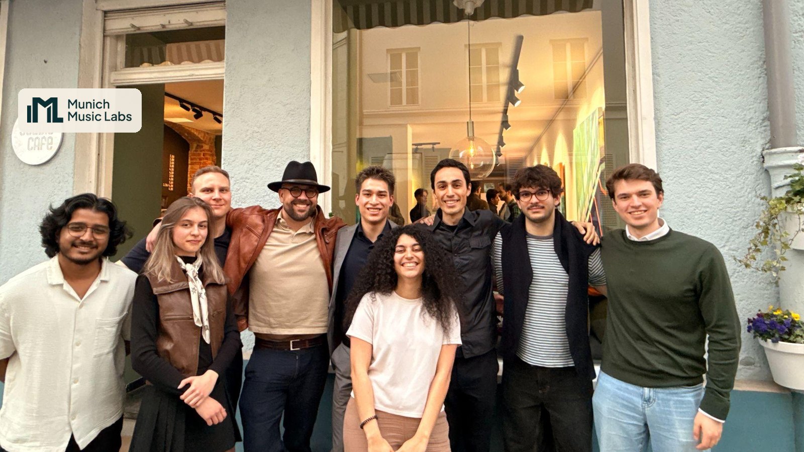 The Munich Music Labs team together outside Studio Café, with the Munich Music Labs logo