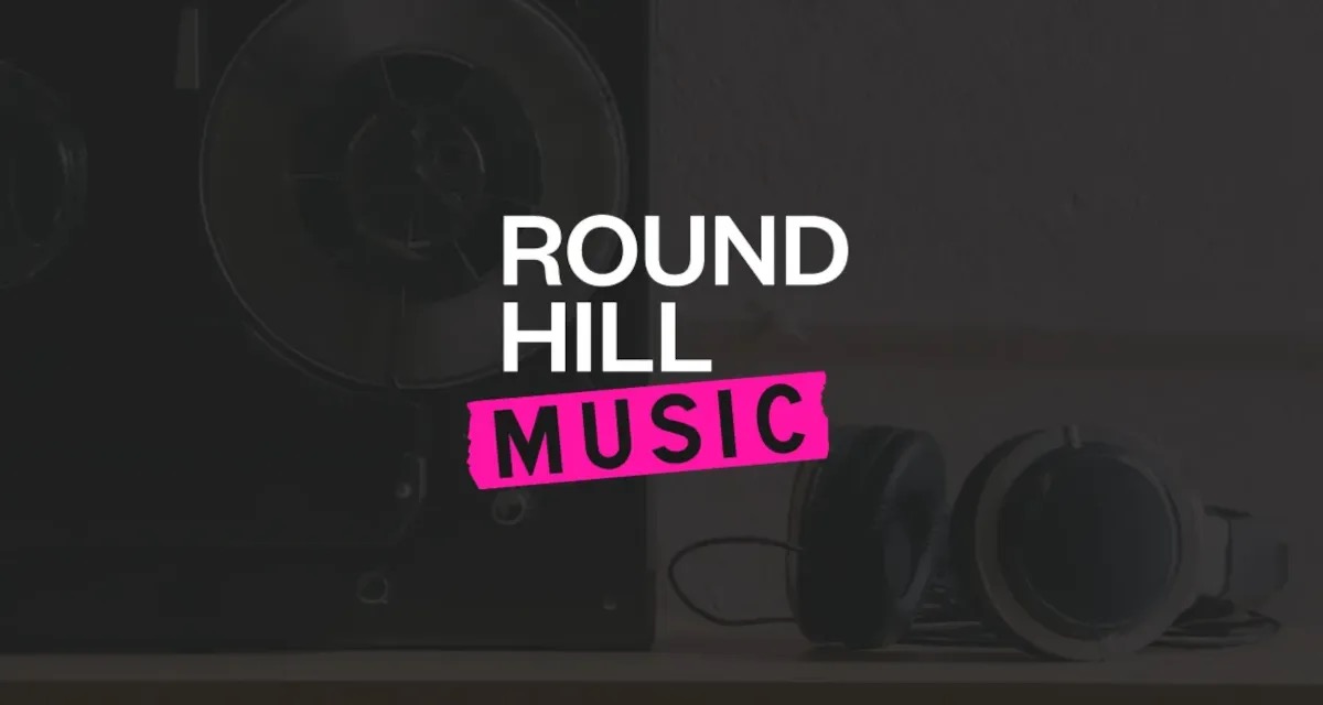Round Hill Music logo over a darkened studio photo of a tape reel and headphones
