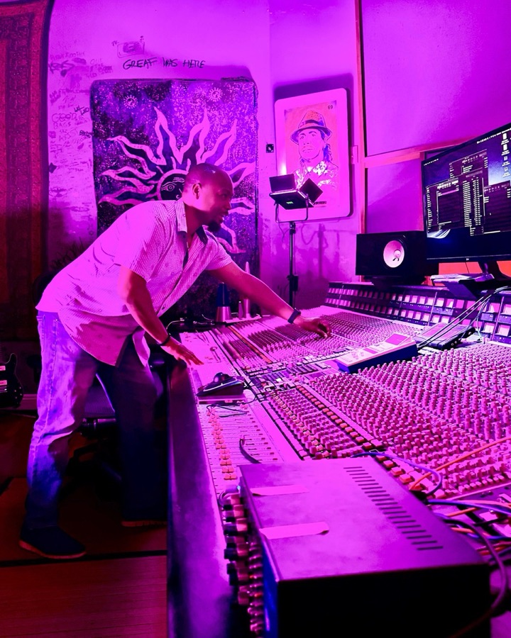 Samori Coles leaning over a large analog mixing console at Lil' Drummaboy Recordings in Philadelphia