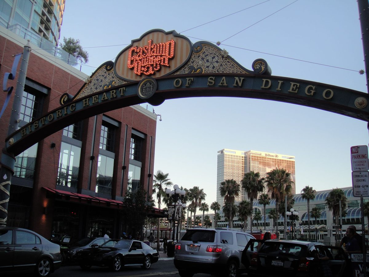 The ornate Gaslamp Quarter archway over a San Diego street reading Historic Heart of San Diego, with brick buildings and palm trees behind.