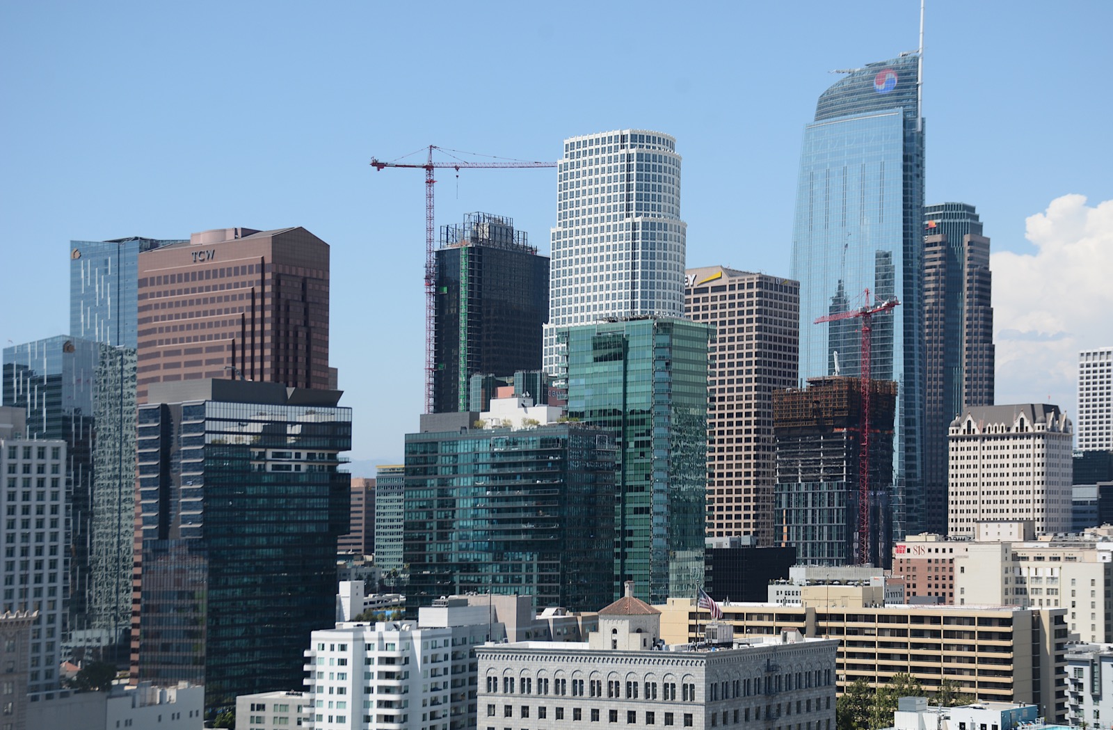 The Downtown Los Angeles skyline seen from Bunker Hill on a clear day, with construction cranes between the towers.