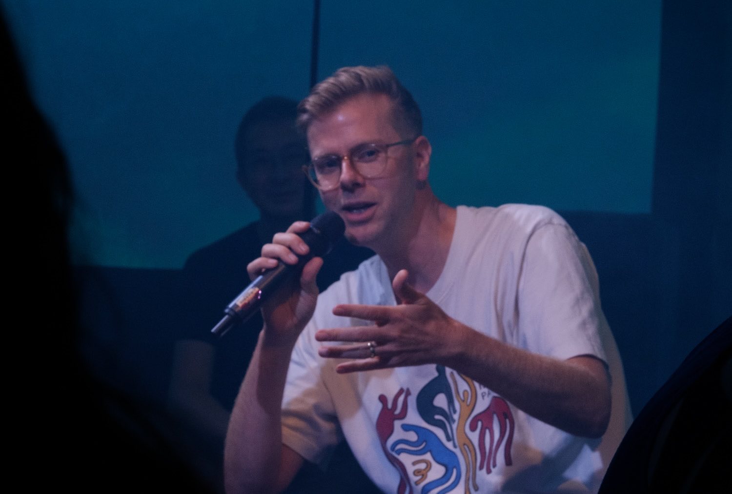 Sound of Fractures speaks into a microphone under blue light at his Alone Together event in London