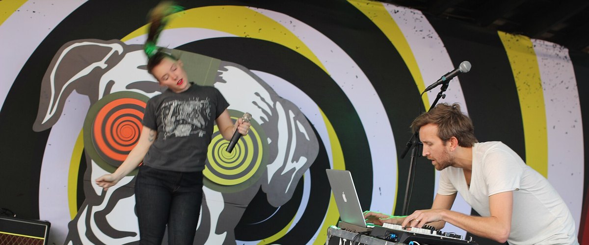Sylvan Esso's Amelia Meath singing and Nick Sanborn playing keyboards on stage in 2017