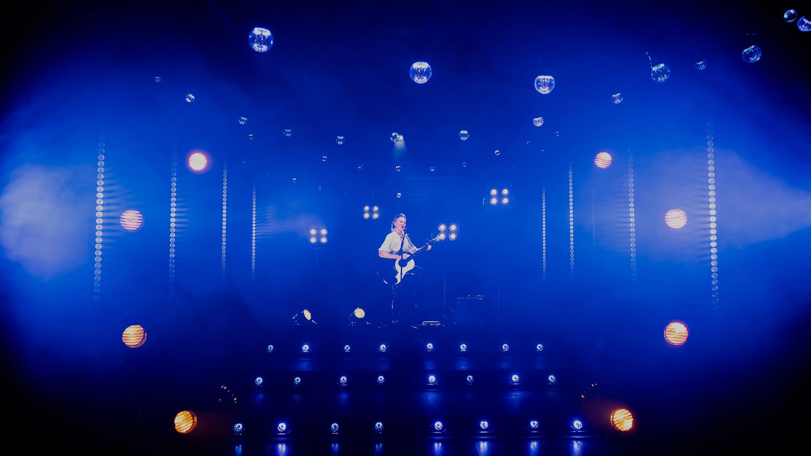 A digital avatar of KT Tunstall performing with a guitar on the Unit1 Studio concert stage