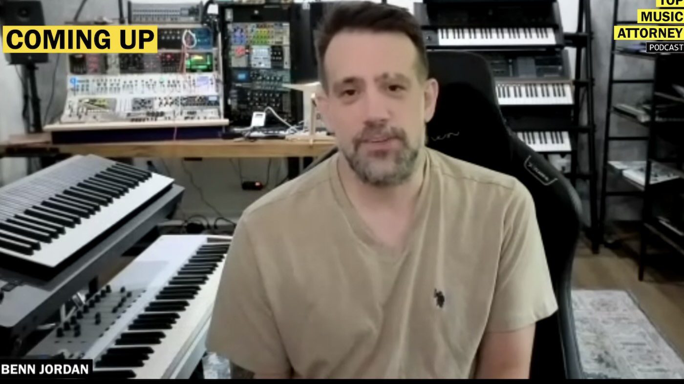 Benn Jordan with short brown hair and a beard sits in a room with various musical keyboards and equipment. Text in the upper left corner reads "COMING UP" and his name, "BENN JORDAN," is displayed at the bottom. This is Benn Jordan on the Miss Krystle Podcast.