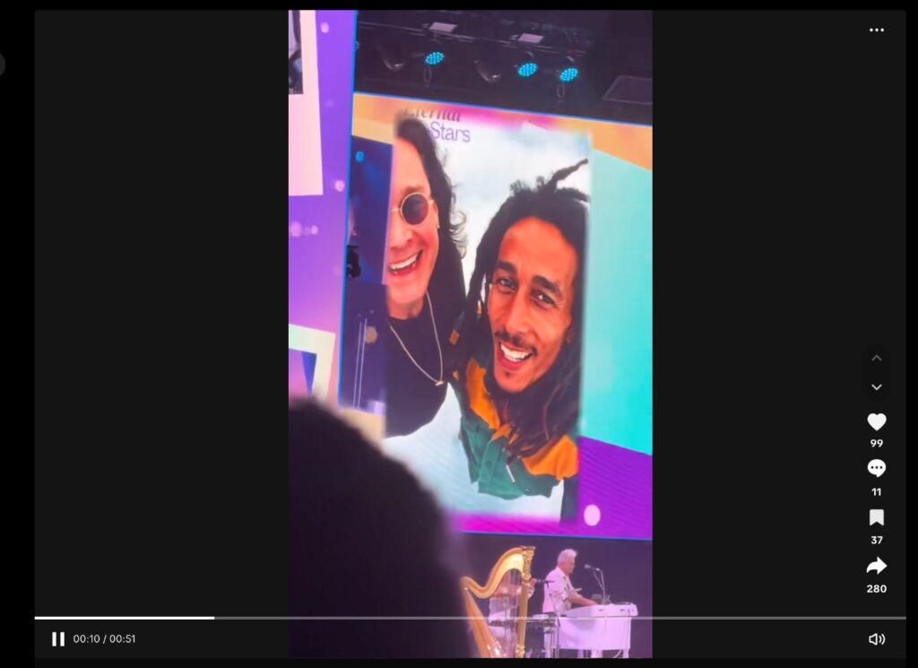 Prince and Ozzy Osbourne take a selfie on on stage shown at a Rod Stewart concert surrounded by colorful visuals. An AI tribute to Ozzy.