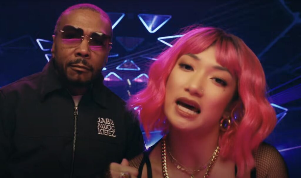 Timbaland and TaTa Taktumi in a futuristic music video scene with neon lights and pink hair
