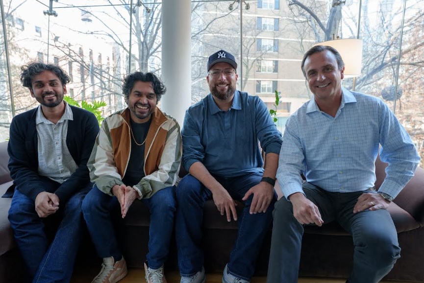 The Beatstars and Lemonaide AI team sitting together smiling in an office with windows overlooking buildings.