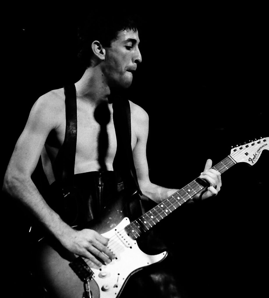 Hillel Slovak performing with Fender Stratocaster in black and white concert photography.