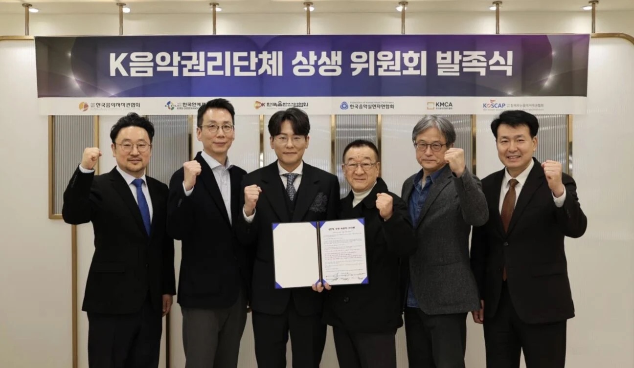 Six Korean music rights leaders raise fists at the K-Music Rights Organizations AI Committee launch ceremony.