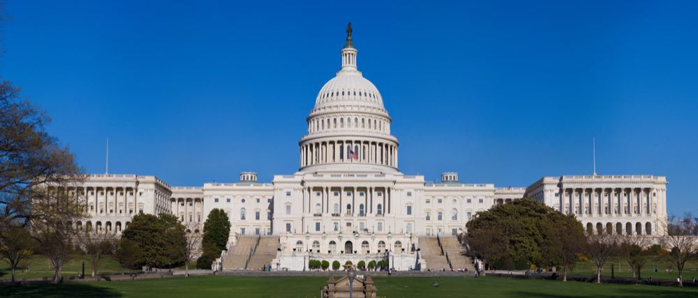 US Capitol Building full front view with reflecting pool and surrounding grounds, Washington DC.