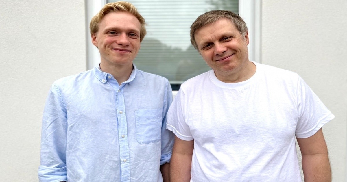 Delphos co-founders Ilya and Roman standing together smiling outdoors.
