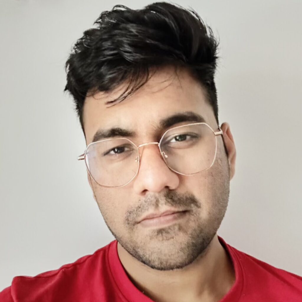 Palaash Agrawal, founder of Veena Studio, wearing a red shirt and octagonal glasses.
