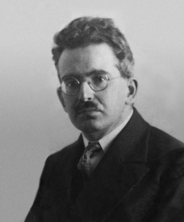 Black and white portrait of philosopher Walter Benjamin circa 1928 wearing round glasses.