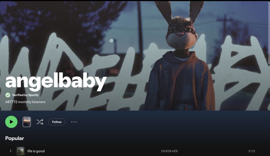 Spotify artist header showing 'angelbaby' with a person in a bunny mask in front of graffiti, conveying a mysterious, urban vibe.